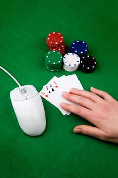 An online gambling concept - computer mouse, hand and casino chips