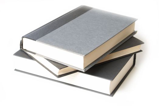 A stack of three hardcover books that are isolated on white.
