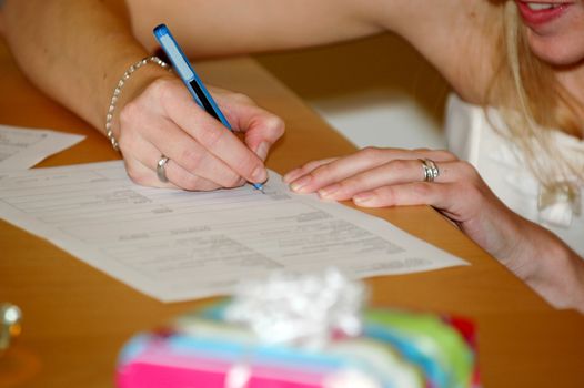 Bride signing the wedding contract. Note that all the tekst is in blur.