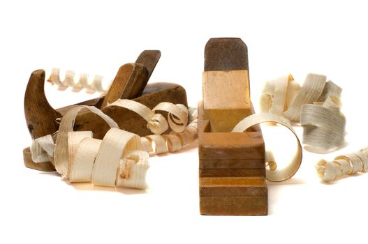 Wood shavings and old planes on a white background.