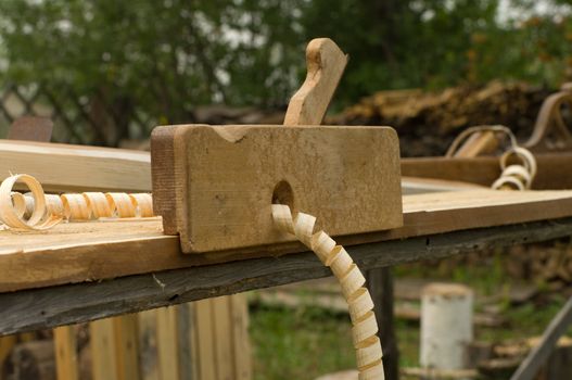 Closeup shot of old wooden plane on the workbench.