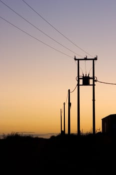 image of power wires and buildings at sunset