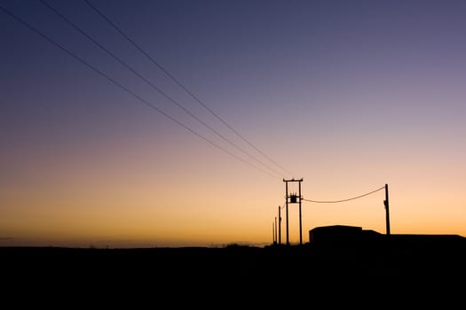 image of power wires and buildings at sunset