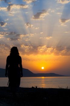 Silhouette of  a beautiful woman walking in the sunset