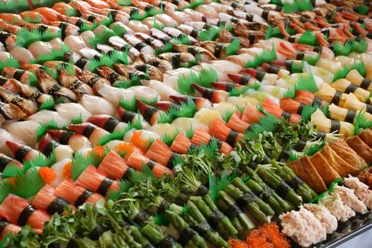 Photo of fresh sushi platter with a lot of variety. Selective focus on middle of the platter.