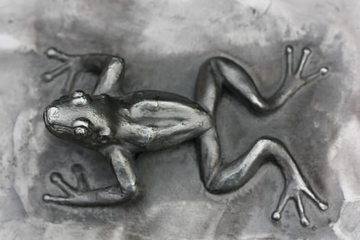 Metal statue of a small frog 

