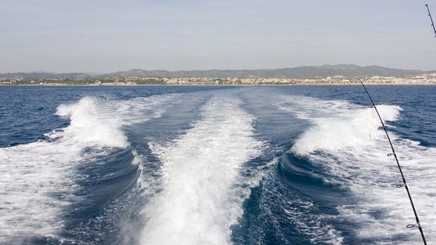 a boat sailing in the sea behind the yacht