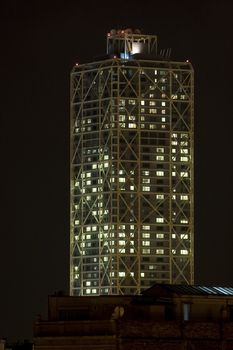 a skycraper building construction at work hours at night