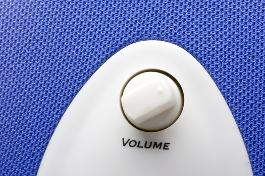 detail of a blue bass speaker with power and volume controls