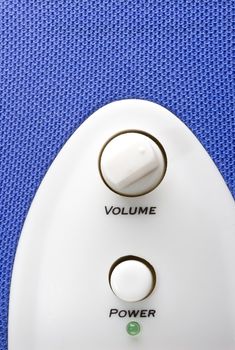 detail of a blue bass speaker with power and volume controls