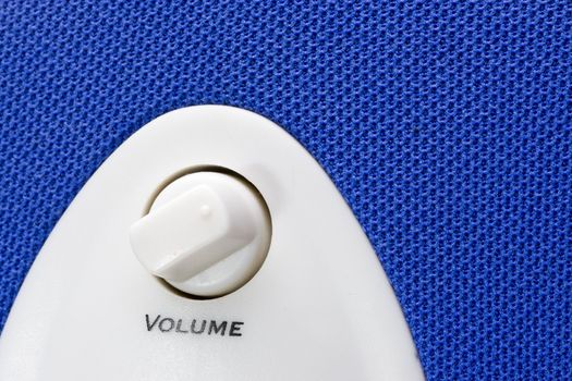 detail of a blue bass speaker with power and volume controls