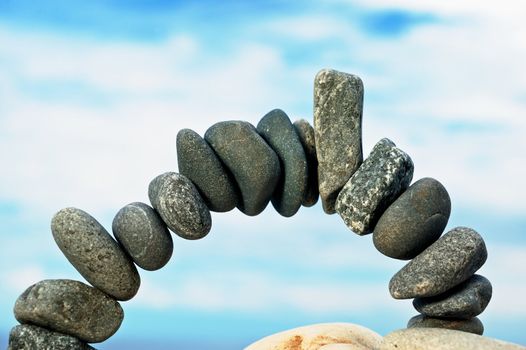 Arch from a dark sea pebble in the summer morning on a beach