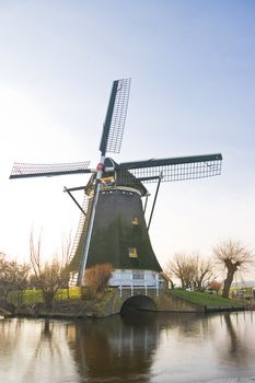 Dutch windmill in frozen winter landscape on a sunny afternoon