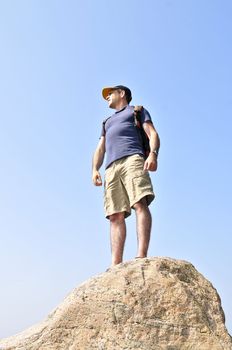 Middle aged hiker standing on top of a mountain