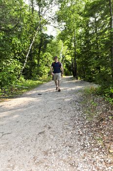Happy middle aged man walking on a forest trail