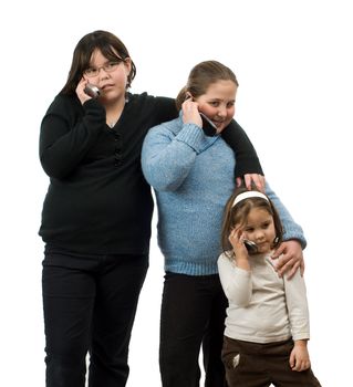 Three young girls of different ages, talking on their cell phones, isolated against a white background