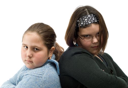 Closeup of two girls standing beside eachother with their arms crossed, trying to look cool