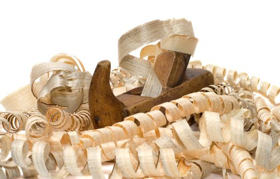 Old wooden plane in a pile of chips on a white background.