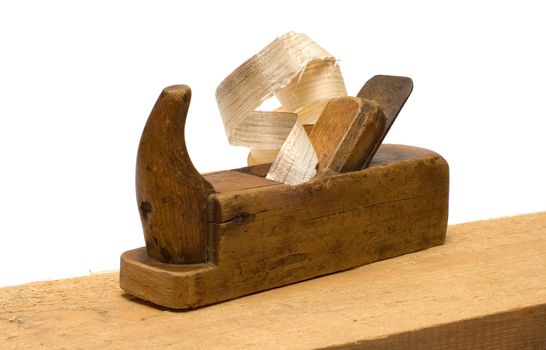 Old wooden plane with the chips on the board isolated on a white background.