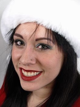 Young pierced woman, in portrait.  A fluffy white hat tames her brunette hair as she smiles brightly.