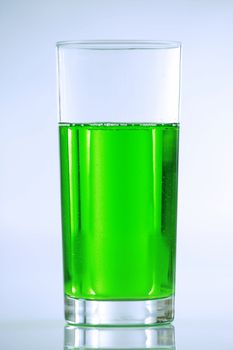 Green drink in tall glass with muted blue tones in background