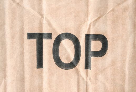 Piece of cardboard with the word TOP on it.