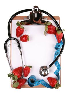 Healthy snack concept with stethoscope and tape measure and strawberries on clip board