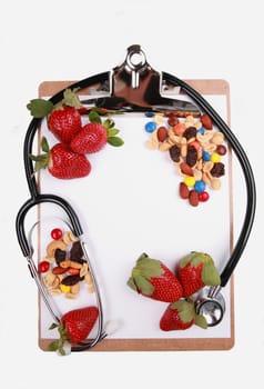 Healthy eating concept, fruits and nuts on clipboard with stethoscope