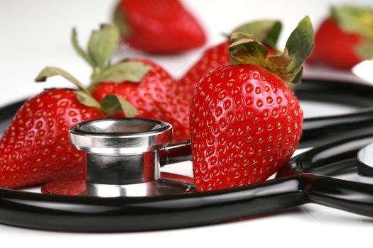Healthy snack, strawberries. Stethoscope with strawberries isolated