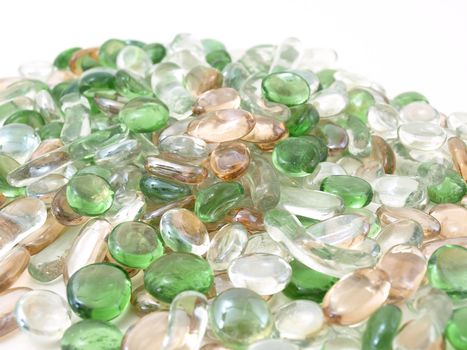 Colorful stones of glass in various green and brown tones isolated over a white background.
