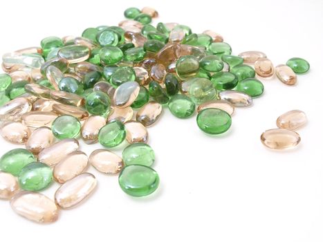Colorful stones of glass in various green and brown tones isolated over a white background.