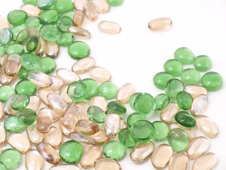 Colorful stones of glass in various green and brown tones isolated over a white background.