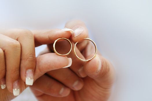 Wedding couple having in their hands beautiful golden rings, symbols of love