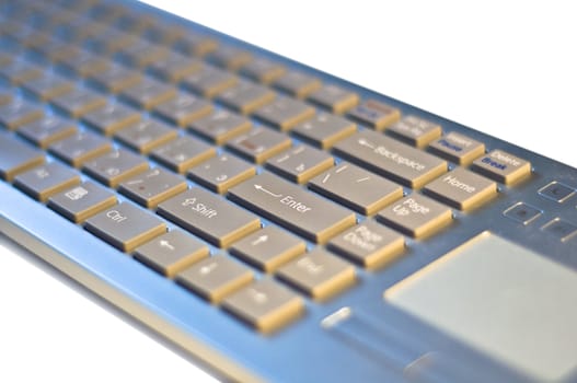 Computer keyboard on a white background. Fragment. Modern Input device with touch pad.