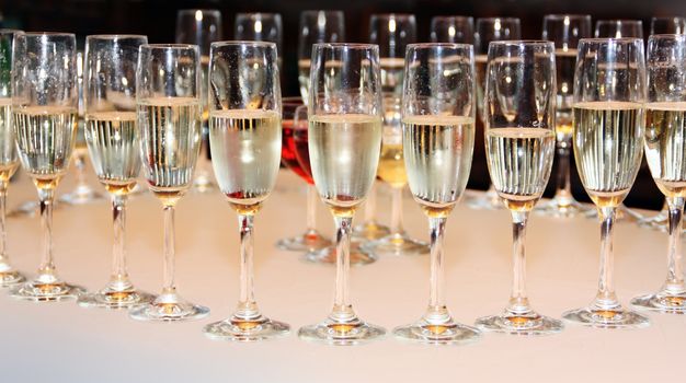 Elegant and transparent glasses filled with gold champagne ready for celebrating
