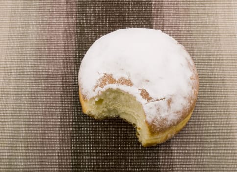 Tasty donut on brown fabric background