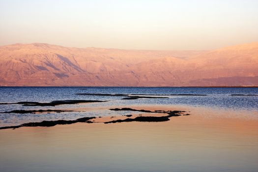 The water of the dead sea with the Jordan mountains at sunset