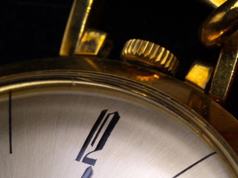 detail of gold pocket watch in warm tungsten light