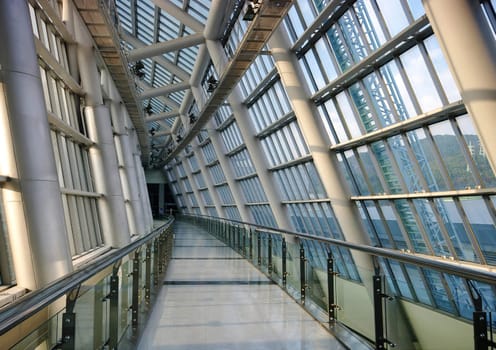 A raised walkway inside a futuristic looking building.