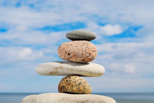 Four different stones in a pile on a beach in the summer at midday