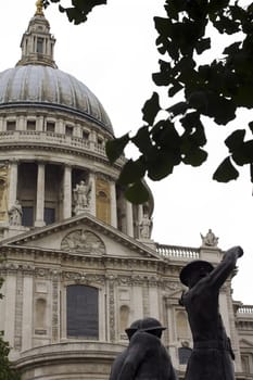 A view of St.Pauls Cathedral in London and its domed roof, seen through the silhouetted shapes of leaves.