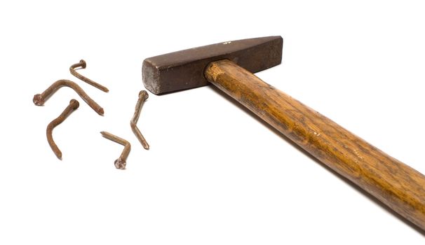 The old hammer and rusty nails bent on a white background.