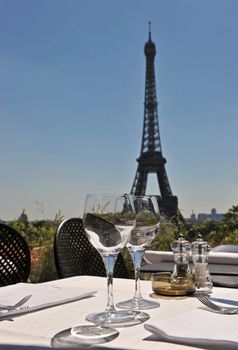 Luxury restaurant with Eiffel Tower behind in a blue sky