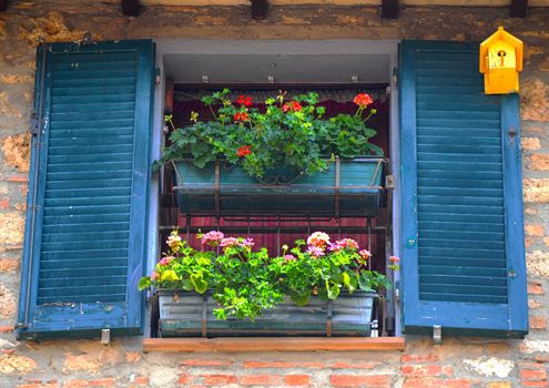 Typical Italian Window With Open Wooden Shutters, Decorated With Fresh Flowers