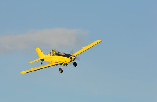 A corp duster or agricultural aircraft flying in a blue sky