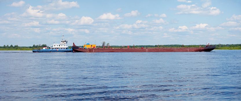 The cargo barge floats on the river