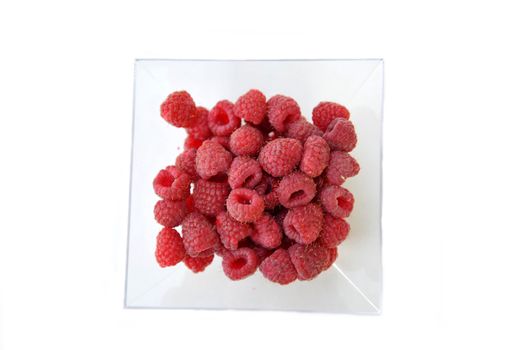 Some berries of a raspberry in a cup on a white background