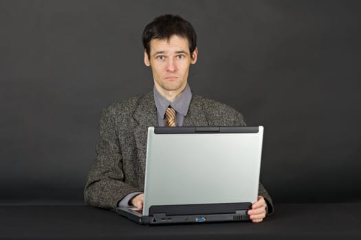 A young man working with laptop computer on a dark background