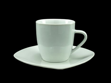 A white cup and saucer over black