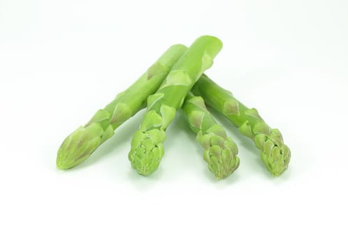 Fresh asparagus heads over white.